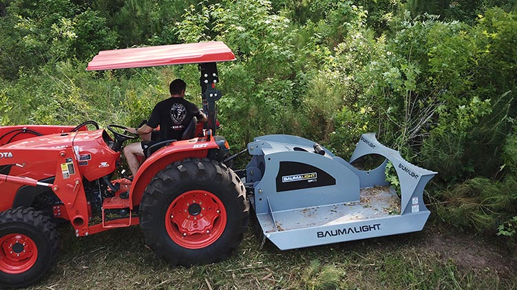 Side view of CP572 brush mower in action