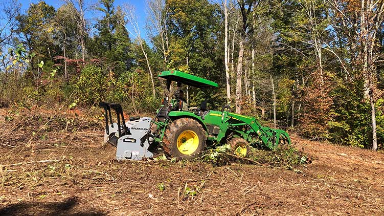 Brushmulcher driven by tractor clearing Brush