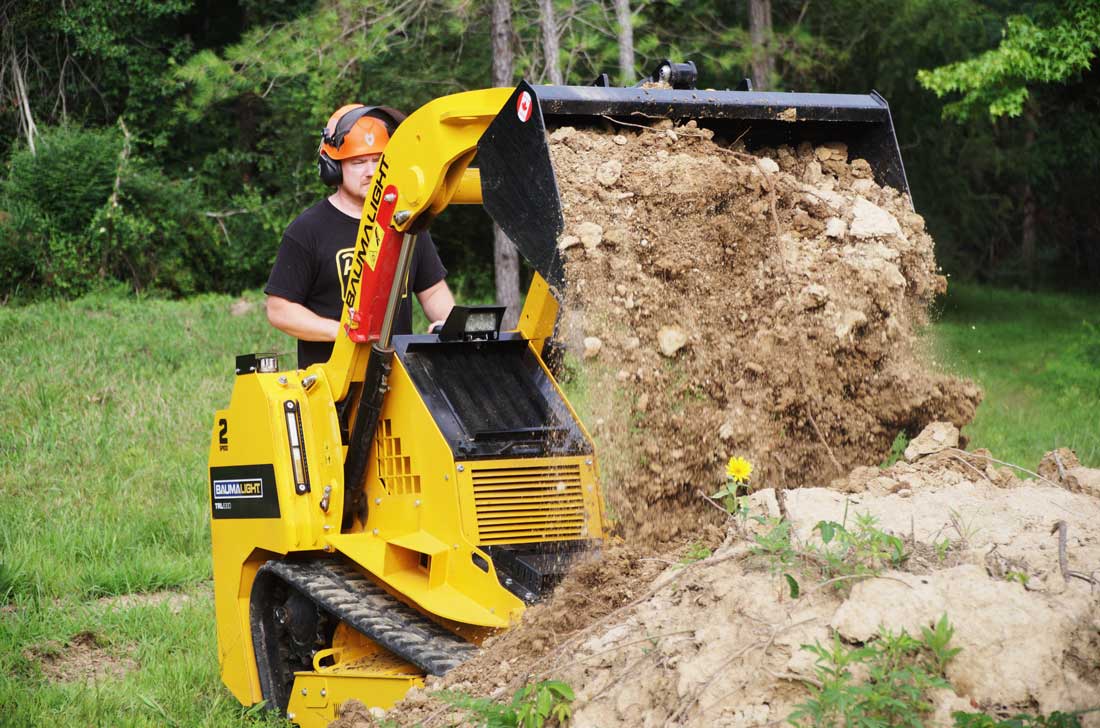 mini-chargeuse compacte sur chenilles, moteur Kubota, TRL630D déversant de la terre depuis le godet