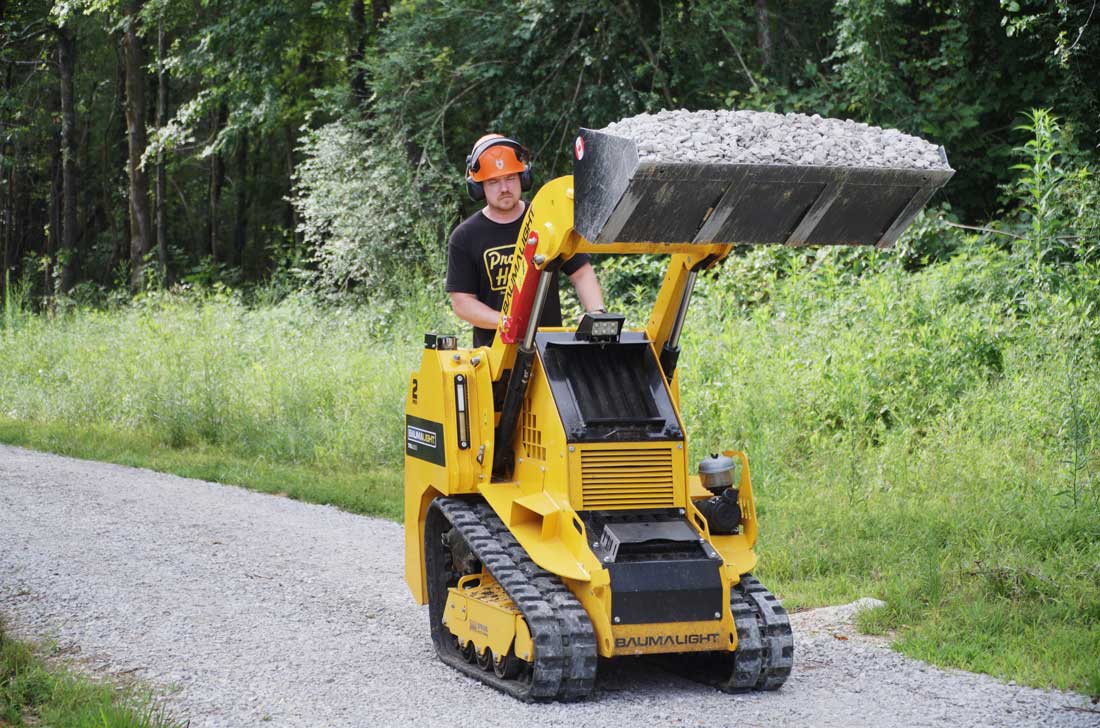 mini-chargeuse compacte sur chenilles, moteur Kubota, TRL630D godet relevé en position de transport
