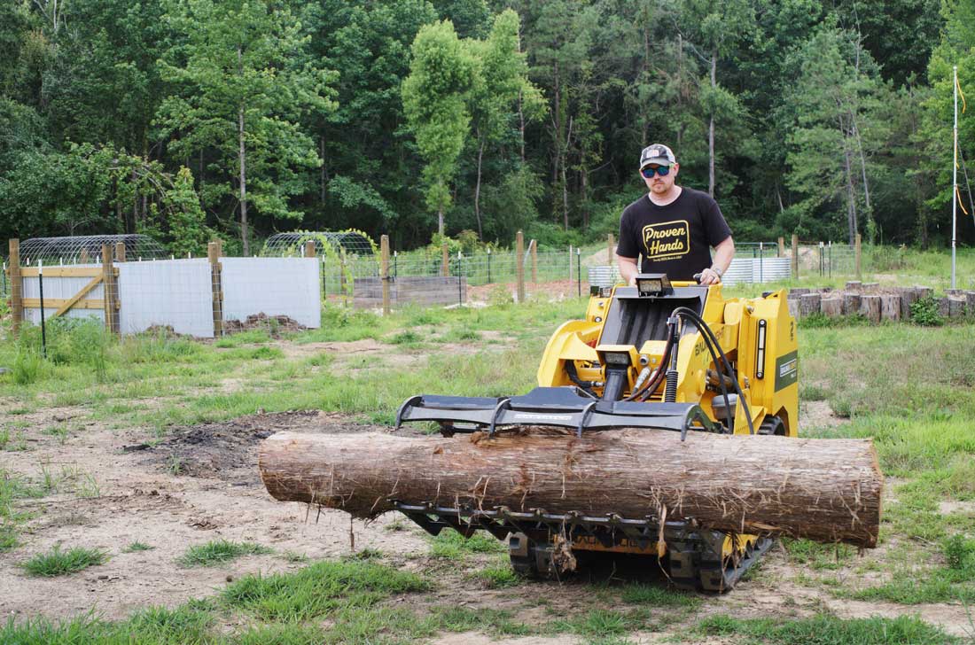 mini-chargeuse compacte sur chenilles, moteur Kubota, TRL630D pince à grumes transportant une grosse bûche