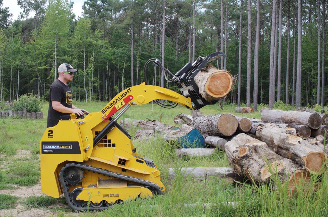 mini-chargeuse sur chenilles, moteur Kubota, pince à grumes TRL630D chargeant une grosse bûche