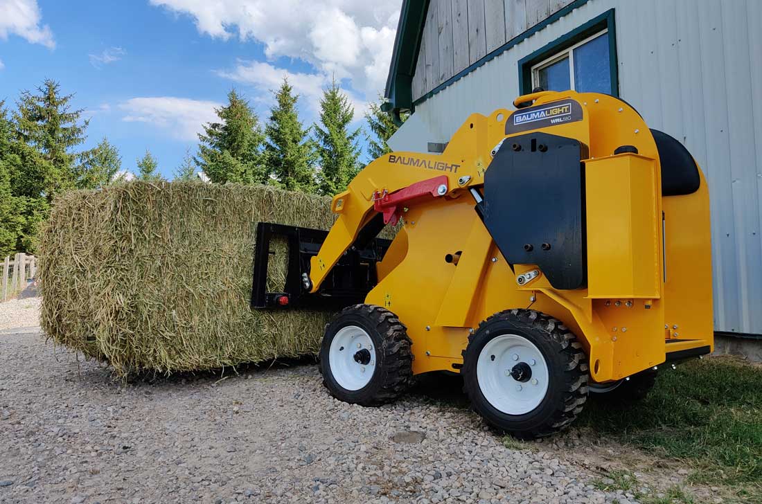 Baumalight mini skidsteer transporting bale