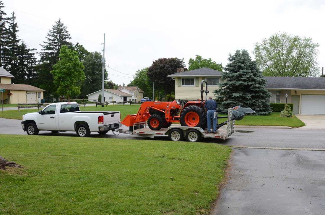 Stump grinder mounted on tractor loaded trailer