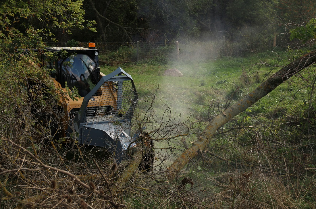 Brush clearing with tree saw on skidsteer